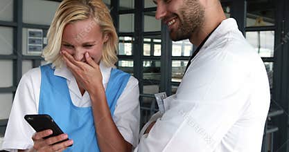 Smiling doctors using smartphone