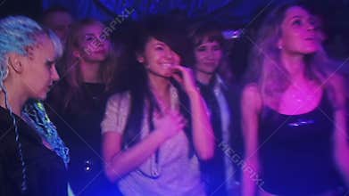 Girl dancing in a club at the party in the light