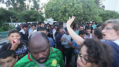 War refugees stand in a queue to receive humanitarian aid - water and apples.
