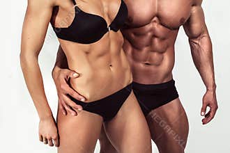 Bodybuilding. Strong man and a woman posing on white background