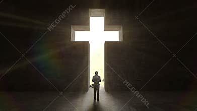 Man standing in front of holy cross on the black wall.