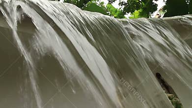 Low angle CU of a small manmade waterfall in tropical Southeast Asia