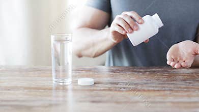 Close up of man pouring fish oil capsules to hand