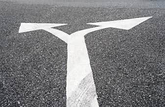 Two way arrows symbol on asphalt road