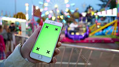 Close up of female hands holding smart phone with a green screen