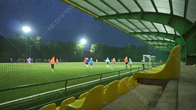 Amateur football game slow motion bokeh video. Empty tribune wide view