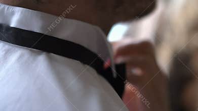 Man corrects businessman bow tie