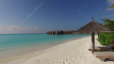 Palapa and sunbeds over bungalow in sea on beach