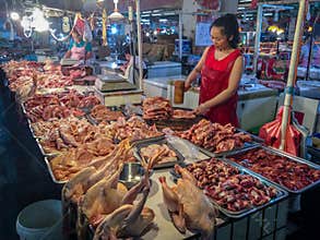 A street meat vendor works in a local market in China