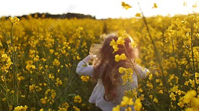 Girl running cross the field at sunset.Slow motion