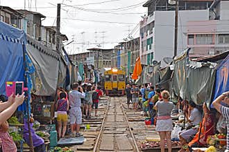 Tourists taking pictures of the incoming train while vendors cleared all their fresh produce