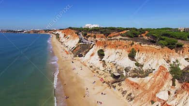People relax on the beach near ocean under the cliffs Portugal aerial view