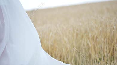 Girl in white dress in the wind, walking through a field of wheat. . slow motion.