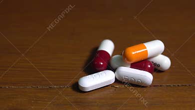 Close up of pills or caplets spinning on a table shot from above