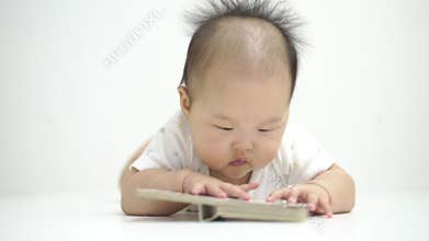 Cute asian baby reading a book