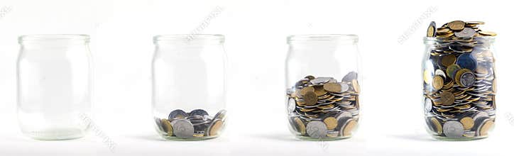 Glass jars with coins like diagram, isolated - savings concept