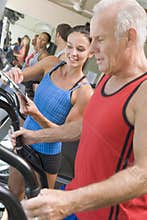 Personal Trainer Instructing Man On Treadmill