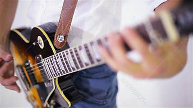Man playing guitar in the studio on a white background, close-up