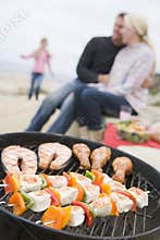 Family Cooking Barbeque On A Beach