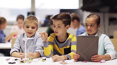 Kids with tablet pc programming at robotics school