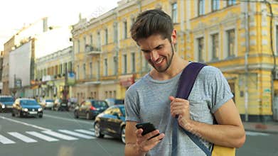 Tourist using his phone in the center of a city.