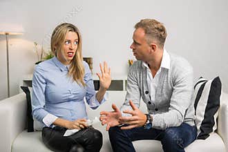 Couple sitting on couch and arguing