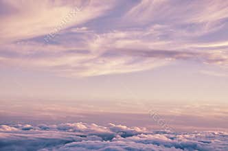 Abstract background with pink, purple and blue colors clouds. Sunset sky above the clouds.