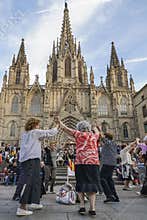 People dancing in front of Holy Cross Cathedral in Barcelona, Sp
