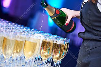 Catering at party event. Waitress pouring wine glasses in restaurant