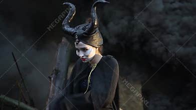 Close-up of sinister girl in the image Maleficent makes flapping cloak