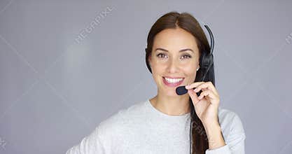 Adorable call center agent speaking with someone on headset