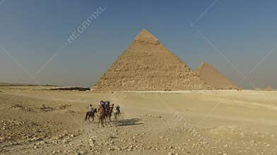Tourists riding camels at Giza pyramids