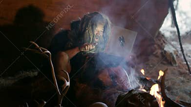 Prehistoric caveman using laptop