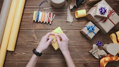 Crop hands decorating wrapped box with string