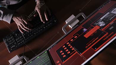 Hacker hands cracking code using computers in dark room.