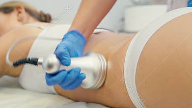 Hardware cosmetology. Woman on the procedure of vacuum-roller massage.