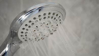 Faucet shower opening expelling water in a bath