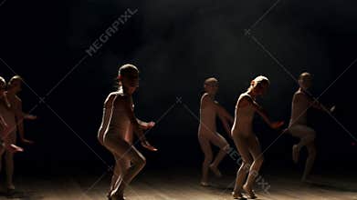 Little cute girls dancing ballet on theater stage on black background in smoke.