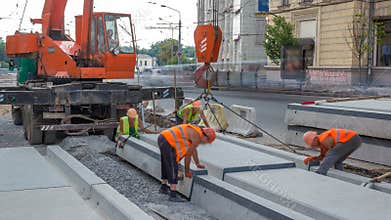 Installing concrete plates by crane at road construction site timelapse.