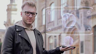 Smart young man with glasses shows a conceptual hologram wrist watch