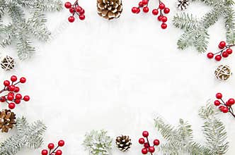 Christmas creative frame made of cones, red berry and fir branches on white background with free space for lettering
