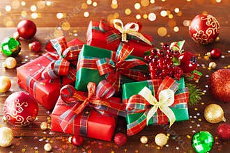 Christmas gift boxes with holiday lights on wooden background