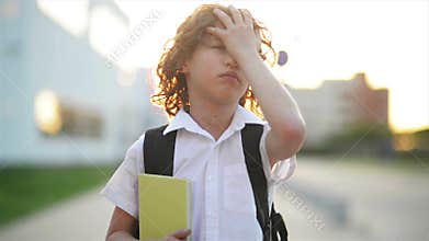 Happy cute clever boy with school bag and book in his hand. Modern backpack. Child is ready to answer. First time to