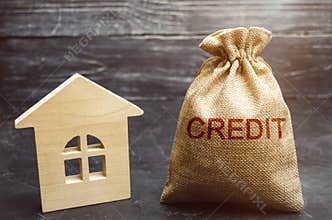 A bag with money and the word Credit near the house. Buying a property in debt. Loan for housing. Mortgage loan to buy an
