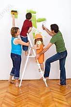 Happy family redecorating the house - painting