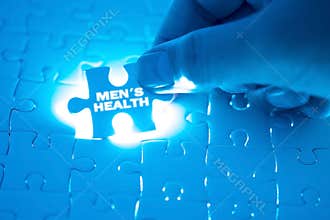 Doctor hand holding a jigsaw puzzle with men`s health word. Conc