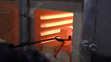 Heat treatment shop. Hot metal part in special tongs