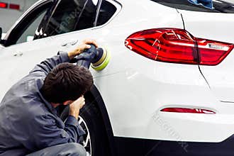 Car detailing - Hands with orbital polisher in auto repair shop