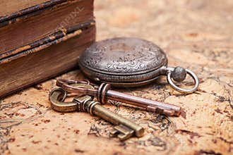 Panta rhei concept: Antique pocket watch, vintage keys and pile of old books on natural cork