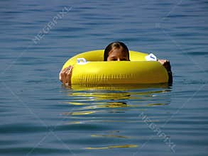 Pretty girl in beach toy (ring) at sea
